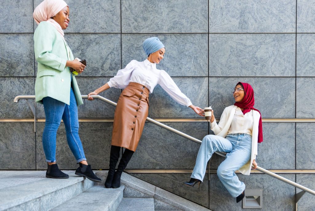 Tiga wanita berhijab memakai outfit kasual dengan sepatu boots