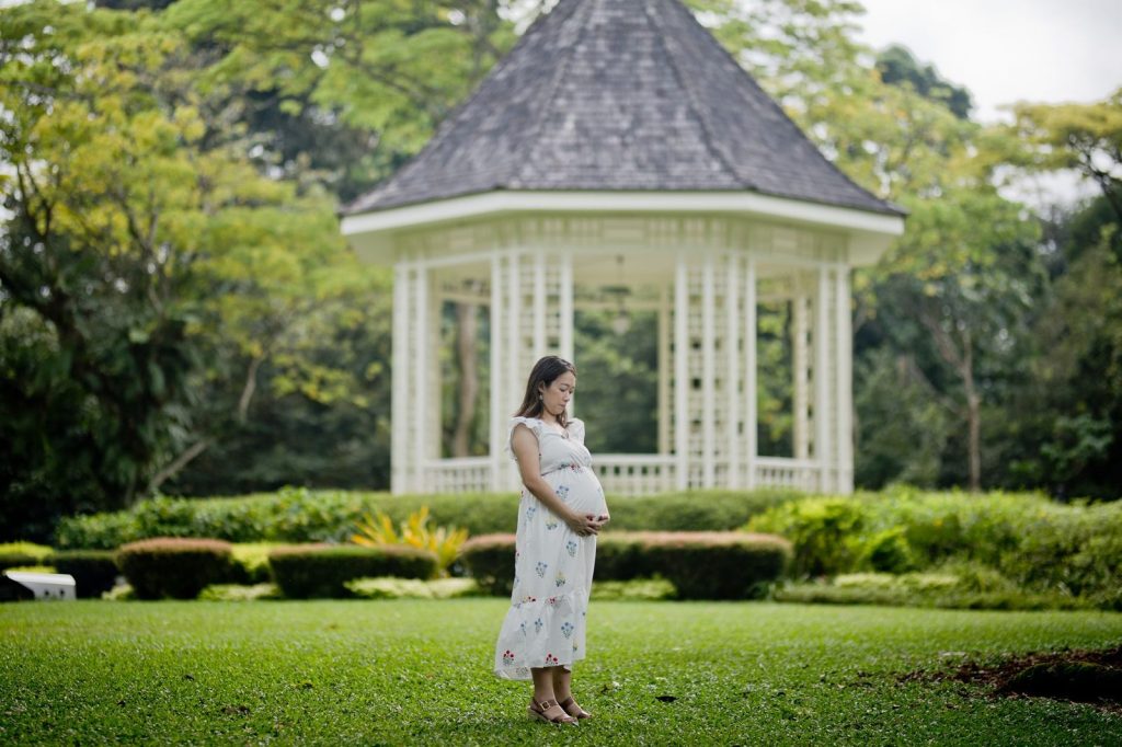 Ibu hamil memakai dress longgar di taman