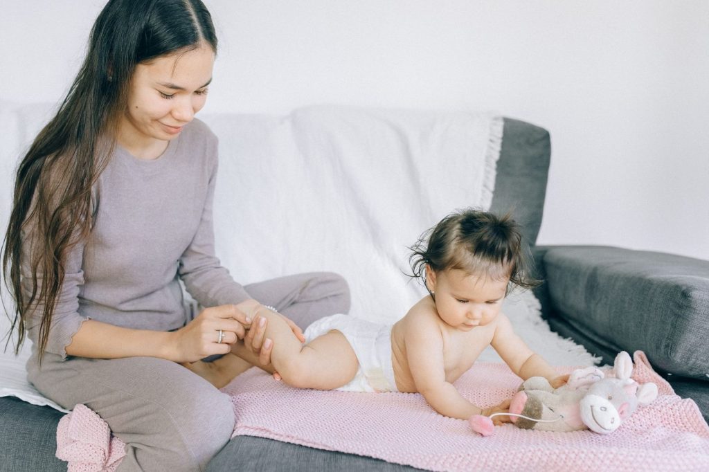 Ibu memijat bayi dengan lotion