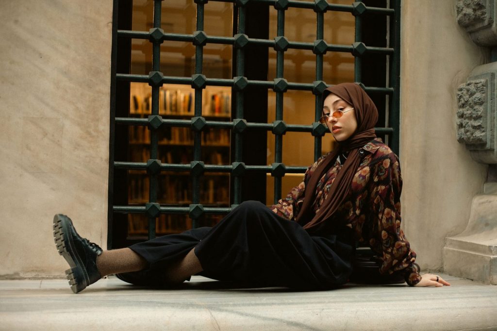 Wanita berhijab memakai outfit stylish dengan sepatu boots