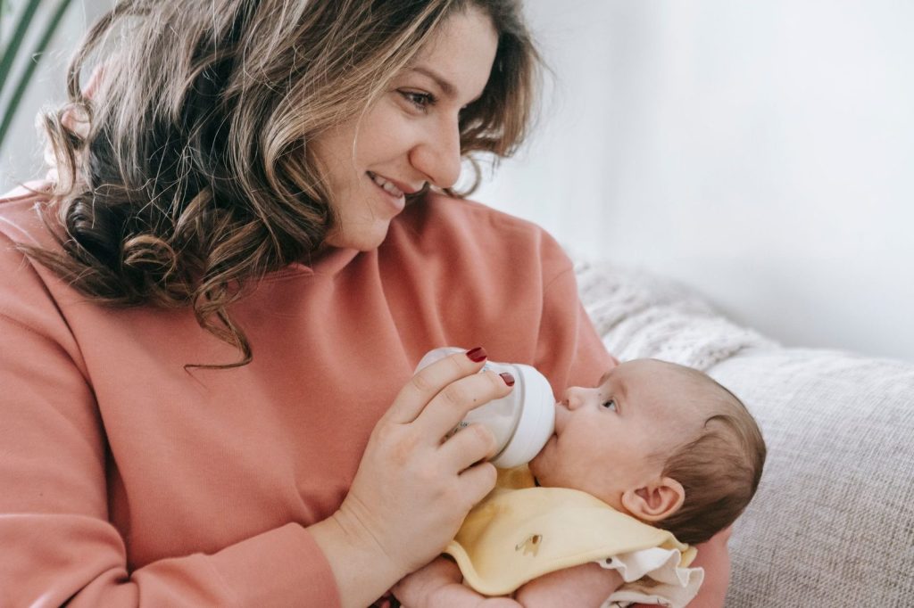 Ibu memberikan ASI perah kepada bayi dengan botol
