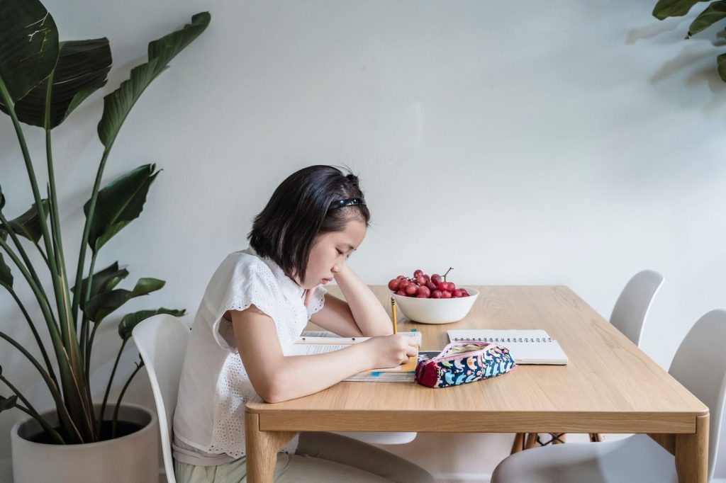 Anak belajar di meja dan kursi belajar